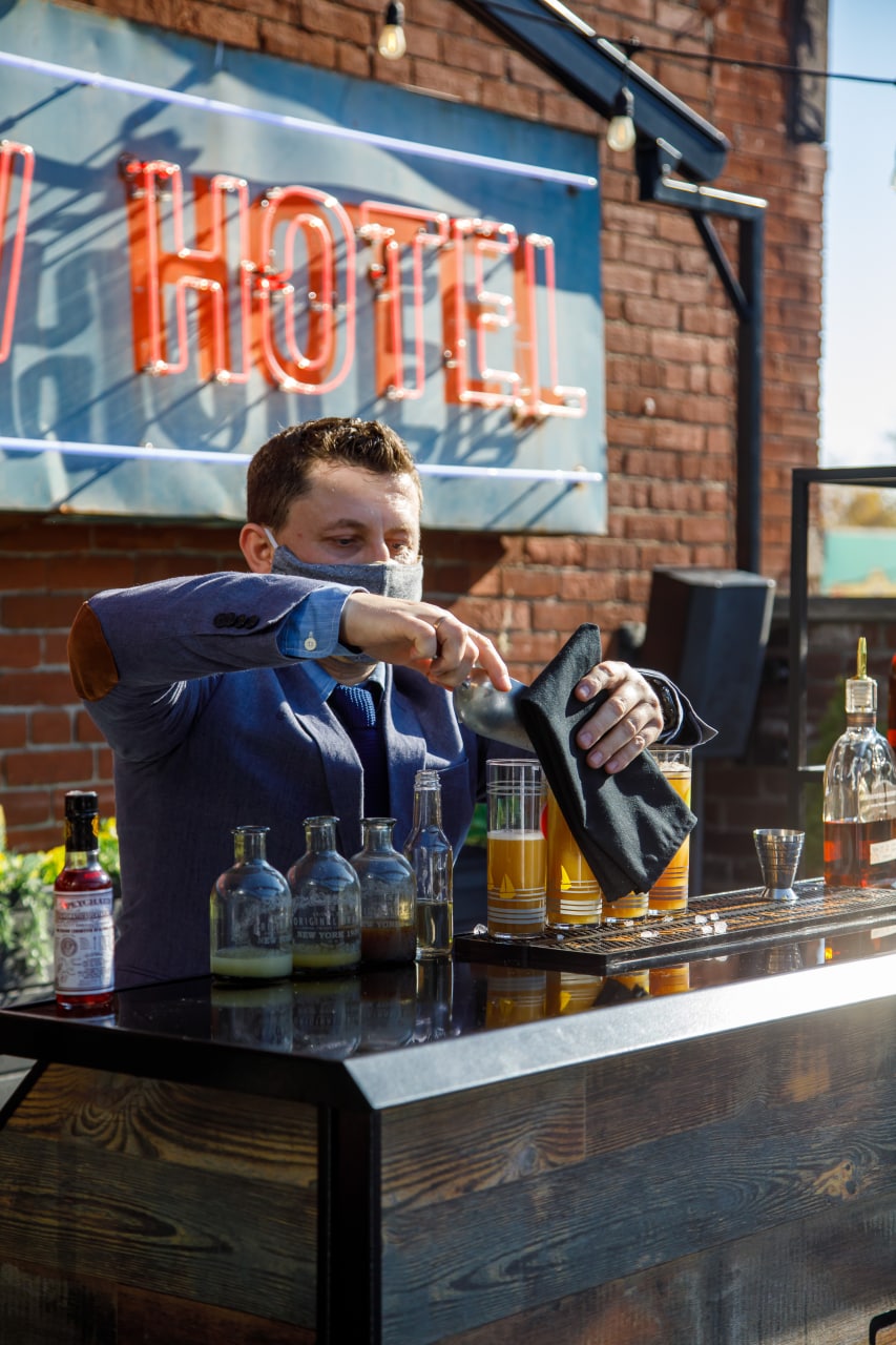 Oleks Iurchenko preparing cocktails at an outdoor event bar